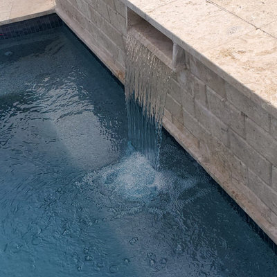 Mid-sized tuscan backyard tile and custom-shaped lap pool fountain photo in Houston