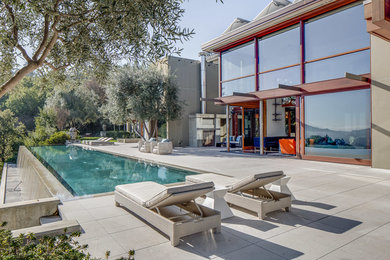 Pool - large modern backyard concrete paver and rectangular lap pool idea in San Francisco