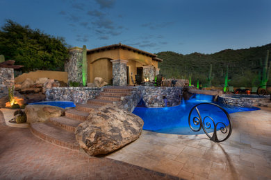Imagen de piscina con fuente mediterránea grande a medida en patio trasero con adoquines de ladrillo