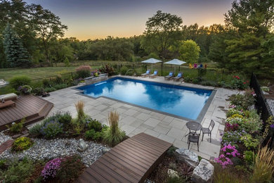 Large trendy backyard tile and rectangular lap pool fountain photo in Toronto