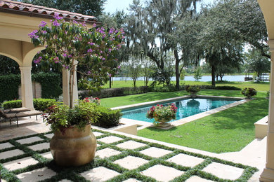 Example of a mid-sized tuscan backyard stone and rectangular pool design in Tampa