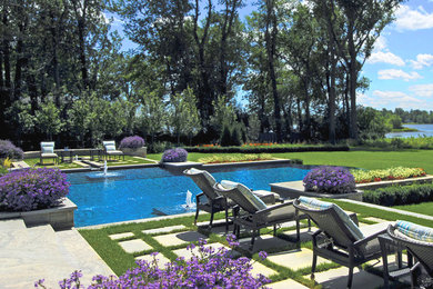 Imagen de piscina con fuente infinita contemporánea extra grande a medida en patio trasero con adoquines de hormigón