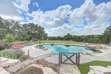 Modelo de piscinas y jacuzzis naturales campestres grandes tipo riñón en patio trasero con adoquines de piedra natural
