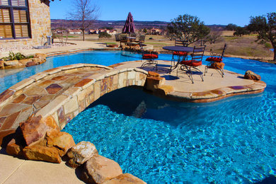 Inspiration for a huge contemporary backyard concrete and custom-shaped infinity pool fountain remodel in Austin
