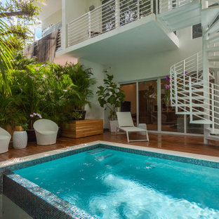 Esempio di una piscina design rettangolare dietro casa con pedane