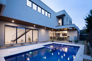 Foto de piscina natural moderna grande rectangular en patio trasero con adoquines de piedra natural