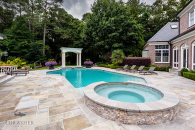 Idéer för att renovera en stor vintage anpassad pool på baksidan av huset, med naturstensplattor