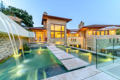 Example of a mid-sized backyard stone pool design in Other