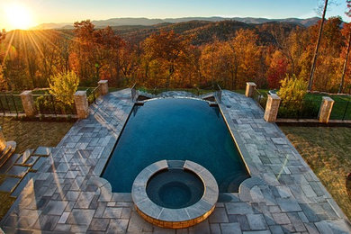 Inspiration for a mid-sized rustic backyard stone and rectangular lap hot tub remodel in Other