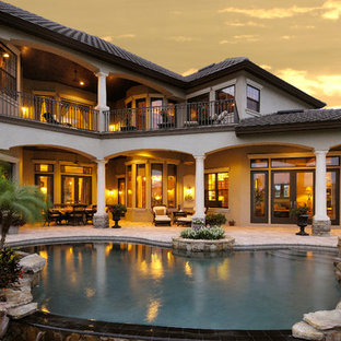 Großer Mediterraner Schwimmteich hinter dem Haus in Nierenform mit Wasserspiel und Natursteinplatten in Tampa