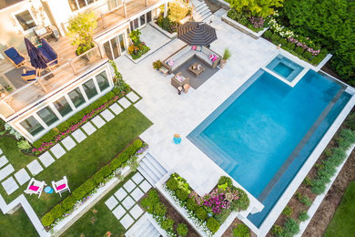 Immagine di un'ampia piscina monocorsia contemporanea rettangolare dietro casa con una vasca idromassaggio e pavimentazioni in pietra naturale