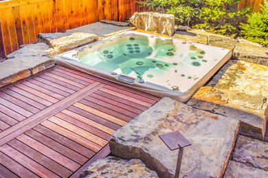 Foto di una piscina tradizionale personalizzata di medie dimensioni e dietro casa con una vasca idromassaggio e pavimentazioni in pietra naturale