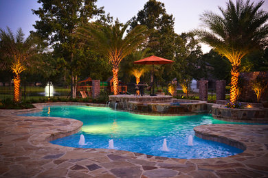 Inspiration for a large tropical backyard stone and custom-shaped pool fountain remodel in New Orleans
