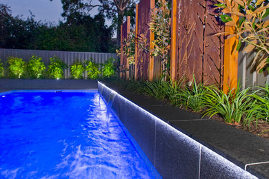 Inspiration pour une piscine à débordement et arrière minimaliste de taille moyenne et rectangle avec des pavés en pierre naturelle.