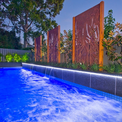 Inspiration for a mid-sized modern backyard stone and rectangular infinity pool remodel in Adelaide