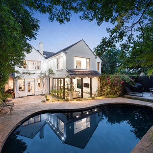 Transitional backyard custom-shaped pool in Melbourne with tile.