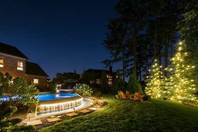 Example of a mid-sized mountain style backyard stone and custom-shaped infinity hot tub design in Atlanta