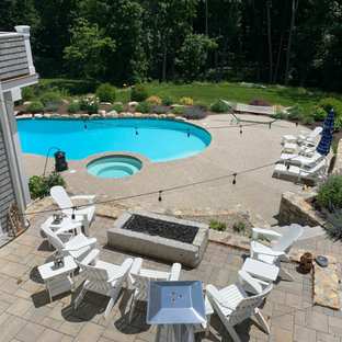 Esempio di un'ampia piscina naturale classica personalizzata dietro casa con pedane