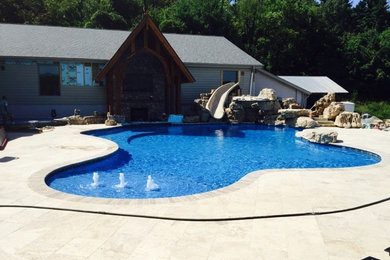 Inspiration for a large backyard custom-shaped natural hot tub remodel in Columbus with decking