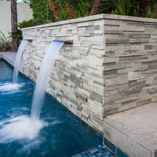 Idee per una piscina moderna rettangolare di medie dimensioni e dietro casa con fontane e pedane