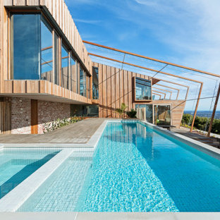 Photo of a contemporary l-shaped pool in Melbourne with a hot tub and decking.
