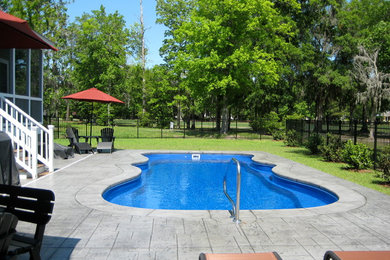 Stamped concrete and custom-shaped pool photo in Charleston