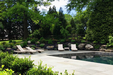 Example of a mid-sized classic backyard stone and rectangular natural pool fountain design in Philadelphia