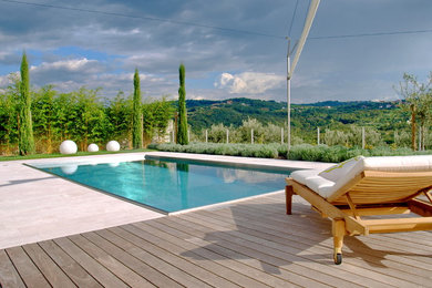 Exemple d'une grande piscine méditerranéenne avec un point d'eau et des pavés en pierre naturelle.