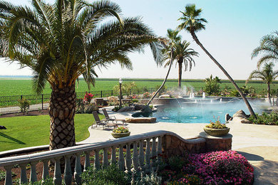 Diseño de piscinas y jacuzzis naturales mediterráneos extra grandes a medida en patio trasero con losas de hormigón