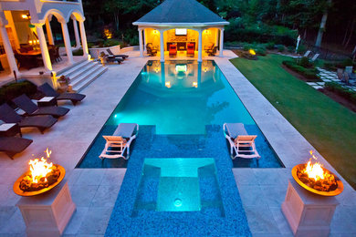 Example of a huge tuscan backyard stone and rectangular hot tub design in Other