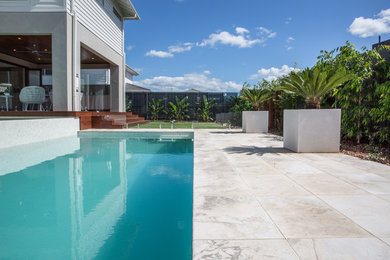 Medium sized contemporary back rectangular lengths swimming pool in Sydney with natural stone paving.