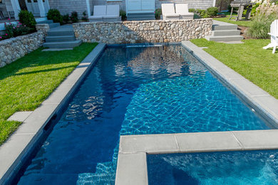 Idee per una grande piscina naturale costiera rettangolare dietro casa con fontane e pavimentazioni in pietra naturale