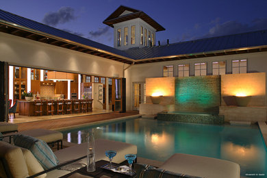 Example of a mid-sized minimalist backyard rectangular natural pool fountain design in Orlando with decking