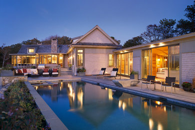Diseño de piscina alargada tradicional renovada grande rectangular en patio trasero con entablado