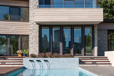Mittelgroßes Modernes Sportbecken hinter dem Haus in rechteckiger Form mit Wasserspiel und Betonboden in Minneapolis