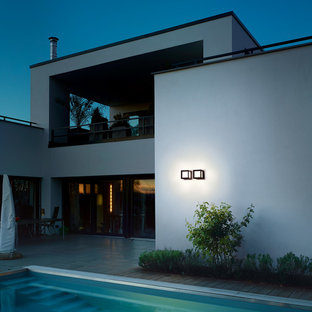 Foto di una piscina monocorsia moderna rettangolare di medie dimensioni e dietro casa con fontane e pedane