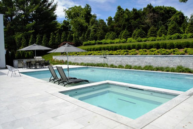 Großer Moderner Pool hinter dem Haus in rechteckiger Form mit Natursteinplatten in New York