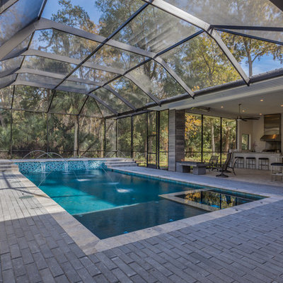 Trendy courtyard concrete paver and rectangular lap pool fountain photo in Jacksonville
