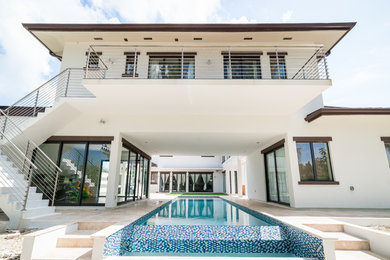 Example of a large trendy courtyard stone and rectangular infinity pool design in Other