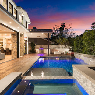 Immagine di una piscina country rettangolare dietro casa con una vasca idromassaggio e pedane