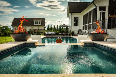 Diseño de piscinas y jacuzzis alargados románticos de tamaño medio rectangulares en patio trasero con adoquines de piedra natural