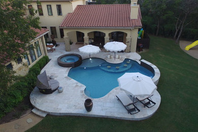 Mid-sized trendy backyard stone and custom-shaped pool photo in Austin