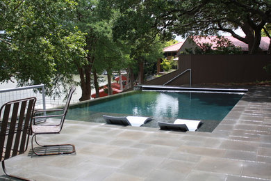Esempio di una piscina a sfioro infinito minimalista rettangolare di medie dimensioni e dietro casa con una vasca idromassaggio e piastrelle