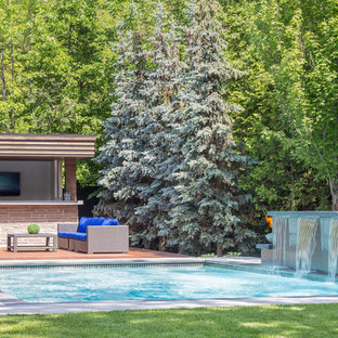 Esempio di una piscina monocorsia minimal rettangolare di medie dimensioni e dietro casa con fontane e pedane