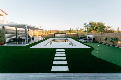 Example of a large minimalist backyard tile and rectangular pool design in Orange County