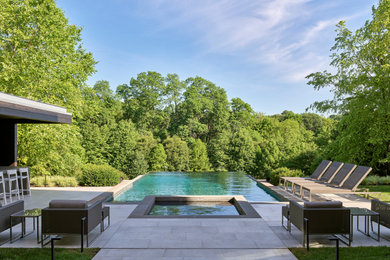Example of a mid-sized trendy tile and rectangular infinity pool design in Philadelphia