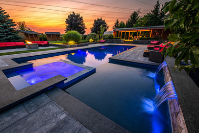 Example of a huge minimalist backyard stone and rectangular lap hot tub design in Toronto