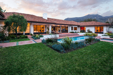 Inspiration for a large contemporary backyard brick and rectangular lap pool fountain remodel in Santa Barbara