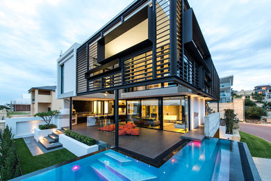 Ispirazione per una piscina minimal a "L" di medie dimensioni e dietro casa con piastrelle