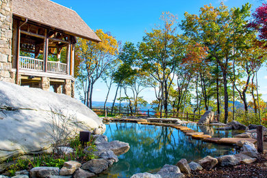 Diseño de piscinas y jacuzzis naturales rústicos extra grandes a medida en patio lateral con adoquines de piedra natural